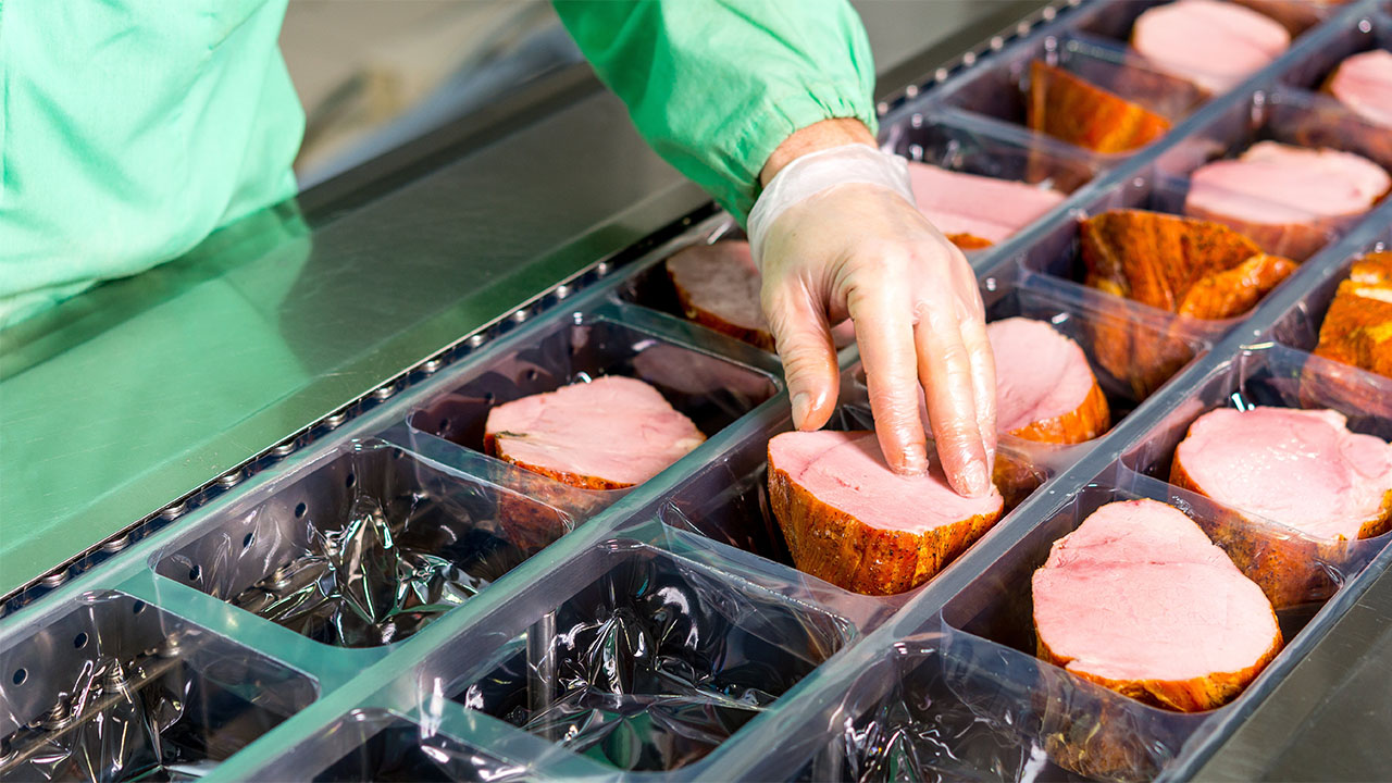 worker-handing-food-at-meat-processing-plant-1280x720